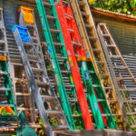 Several colorful ladders leaning up against a wall