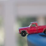 a small toy truck in focus teetering on the edge